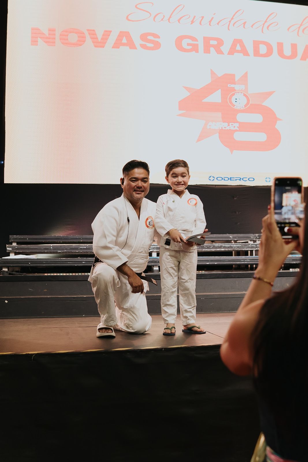 Sensei e aluno com o certificado na Solenidade de Novas Graduações